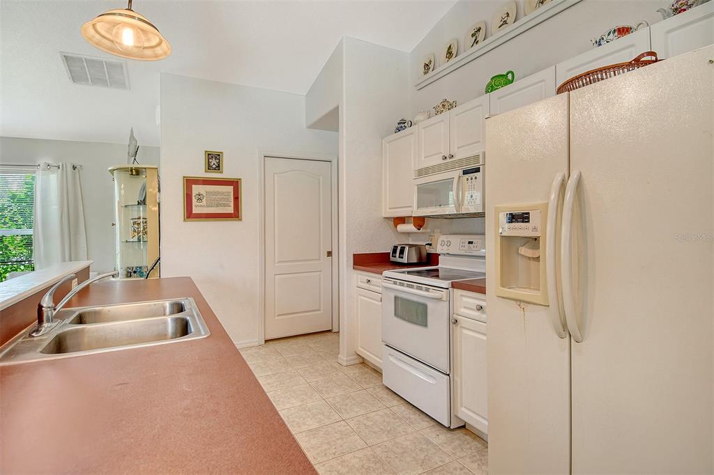 2276 Polaris Road North Port, FL 34291 - Photo 13 of 31 a kitchen with stainless steel appliances white cabinets and a refrigerator