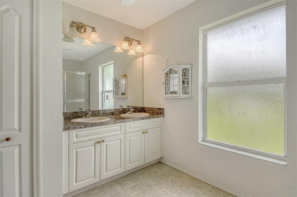 2276 Polaris Road North Port, FL 34291 - Photo 22 of 31 a bathroom with a granite countertop sink a mirror and a shower