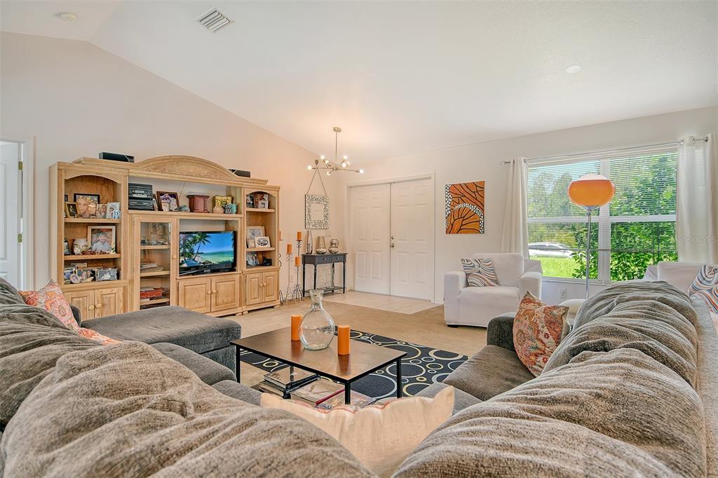 2276 Polaris Road North Port, FL 34291 - Photo 9 of 31 a living room with furniture a flat screen tv and a floor to ceiling window
