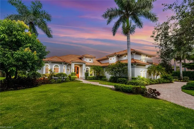 a front view of a house with a garden and yard