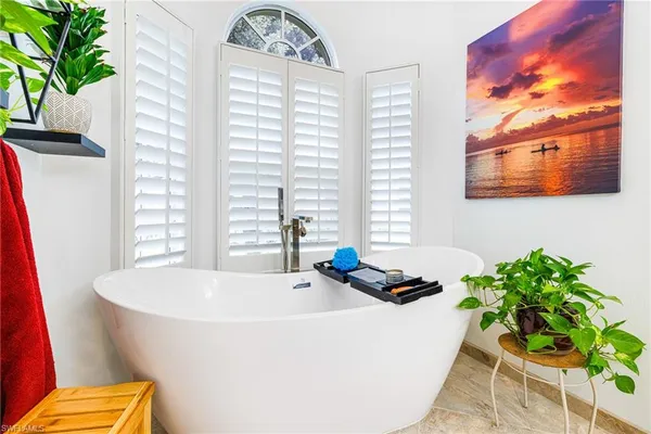 a bath tub sitting in a bathroom next to a window