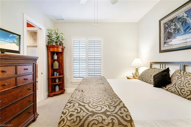 a bedroom with a bed and a flat tv screen on the dresser