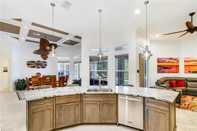 a kitchen with kitchen island granite countertop a sink and a stove