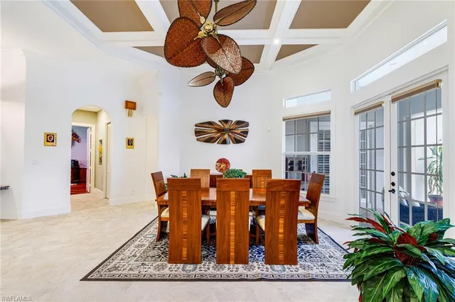 a dining room with chandelier fan and wooden floor