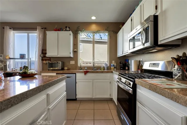 a kitchen with stainless steel appliances granite countertop a stove sink and cabinets