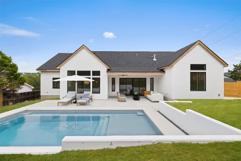 a view of a house with swimming pool and sitting area