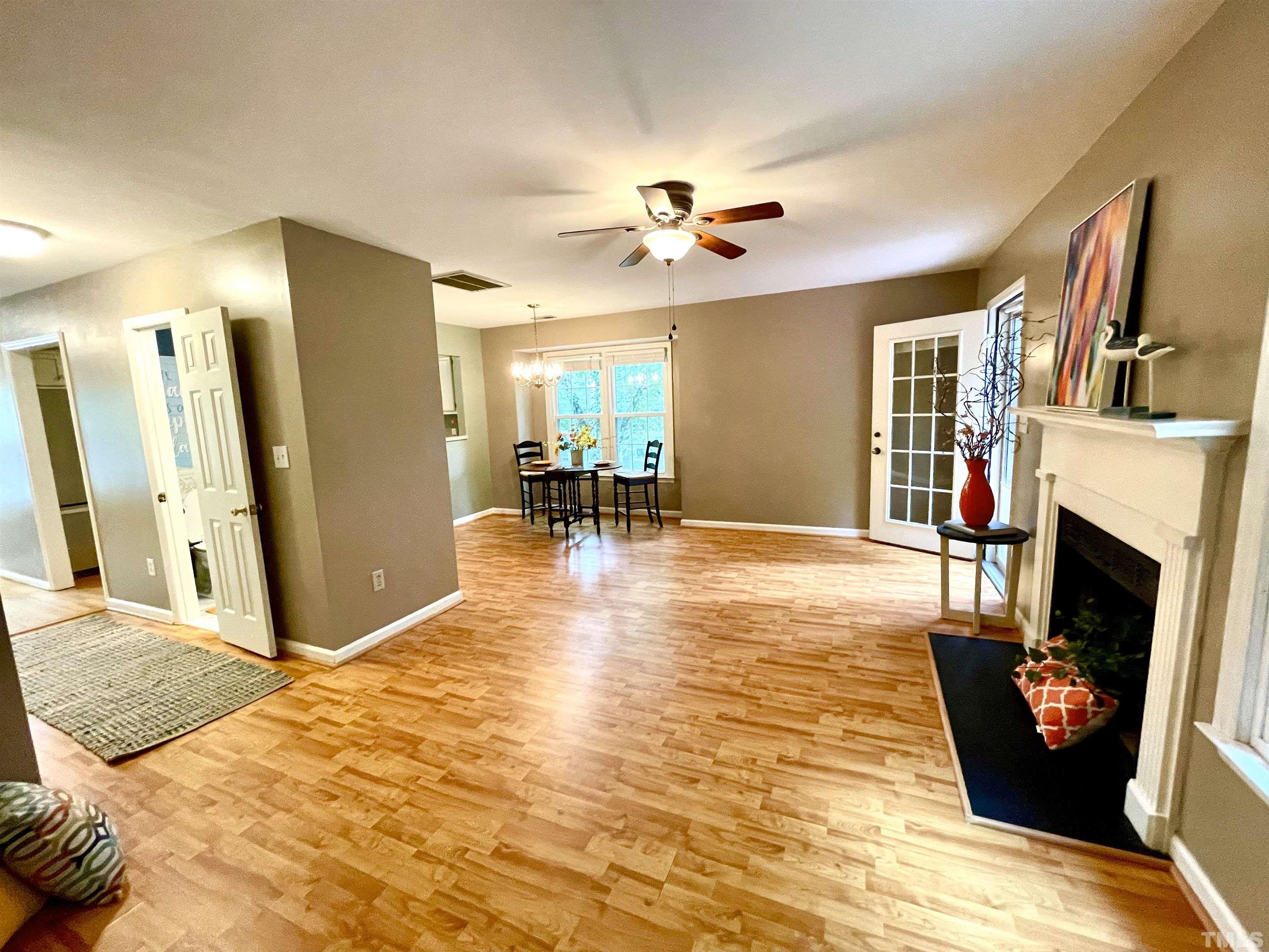 104 Long Shadow Place Durham, NC 27713 - Photo 6 of 11 a view of a livingroom with furniture a fireplace wooden floor and a chandelier