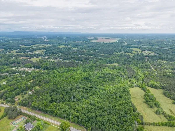 an aerial view of residential houses with outdoor space and trees