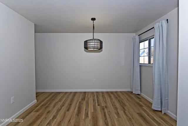 a view of a room with wooden floor and windows