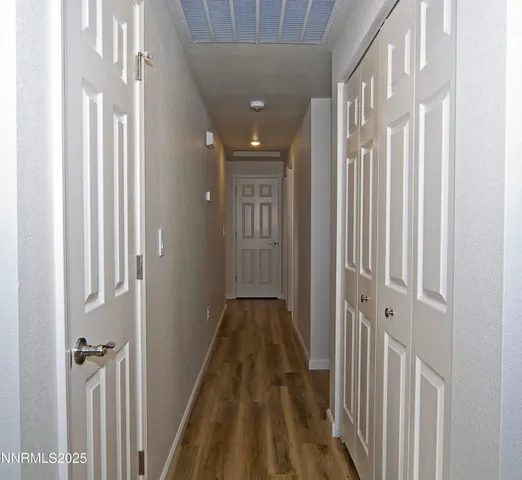 a view of a hallway with wooden floor and staircase