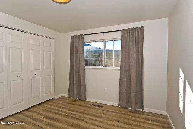 a view of a room with wooden floor and windows