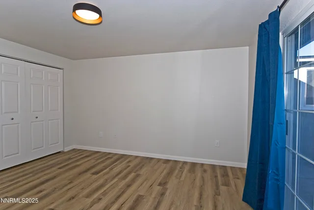 a view of empty room with wooden floor