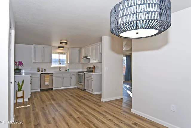 a view of a white house next to a road and a yard