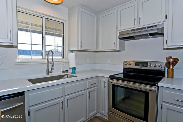 a kitchen with a sink stove and cabinets