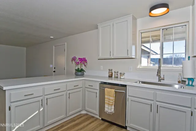a kitchen with white cabinets and sink