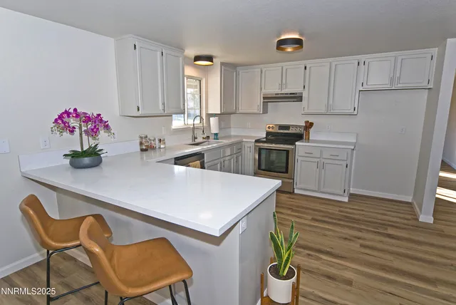 a kitchen with granite countertop a sink cabinets and stainless steel appliances