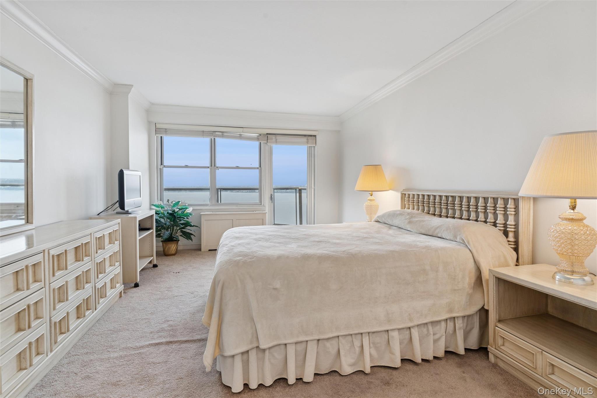 17-85 215th Street, Unit 15M Queens, NY 11360 - Photo 17 of 30 a spacious bedroom with a bed and a window