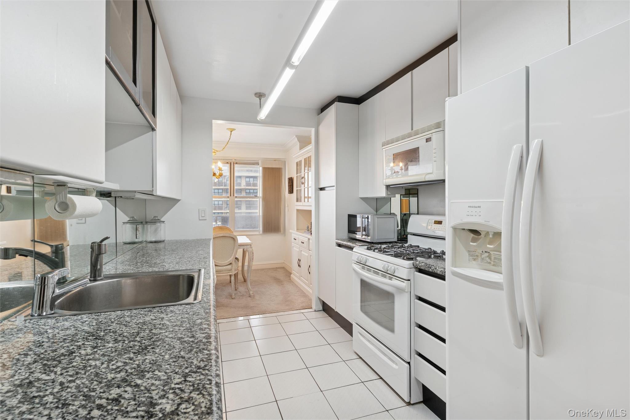 17-85 215th Street, Unit 15M Queens, NY 11360 - Photo 9 of 30 a kitchen with stainless steel appliances granite countertop a sink stove and refrigerator