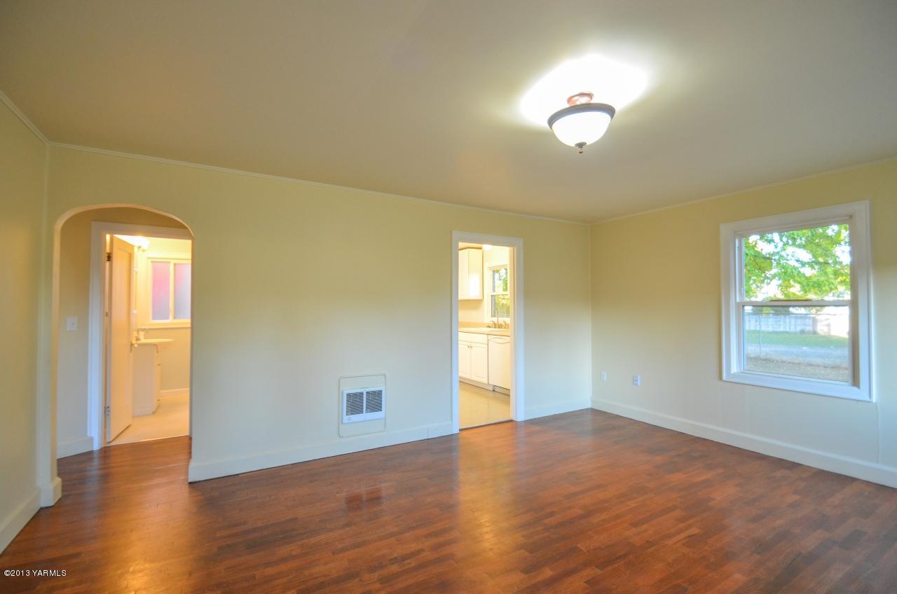 11703 Gilbert Road Yakima, WA 98903 - Photo 3 of 12 an empty room with wooden floor and windows