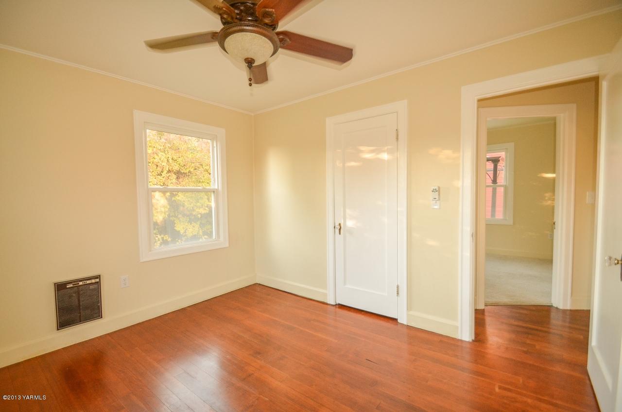 11703 Gilbert Road Yakima, WA 98903 - Photo 6 of 12 a view of an empty room with wooden floor and a window