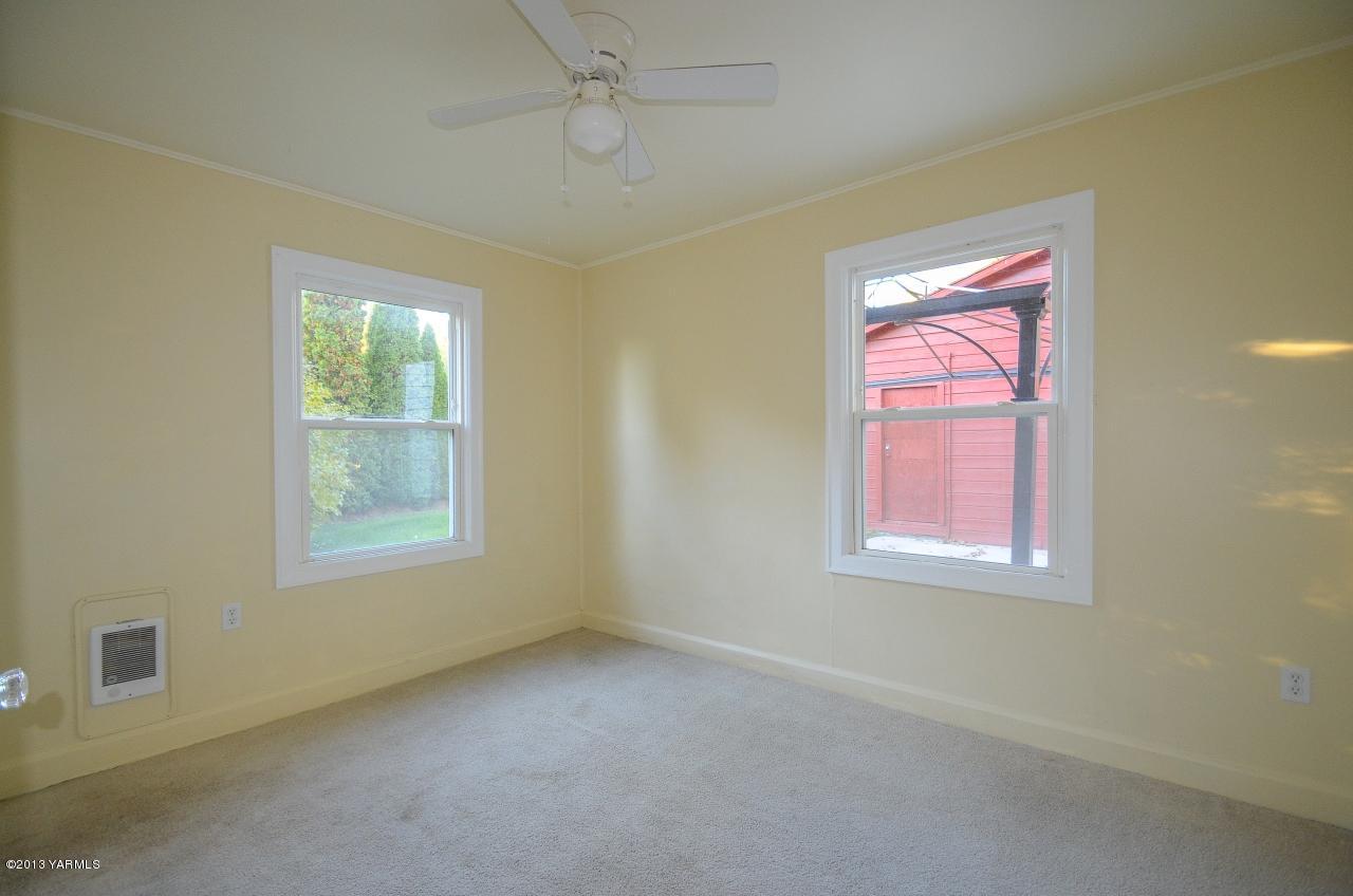 11703 Gilbert Road Yakima, WA 98903 - Photo 7 of 12 a view of a livingroom with an empty space a ceiling fan and window