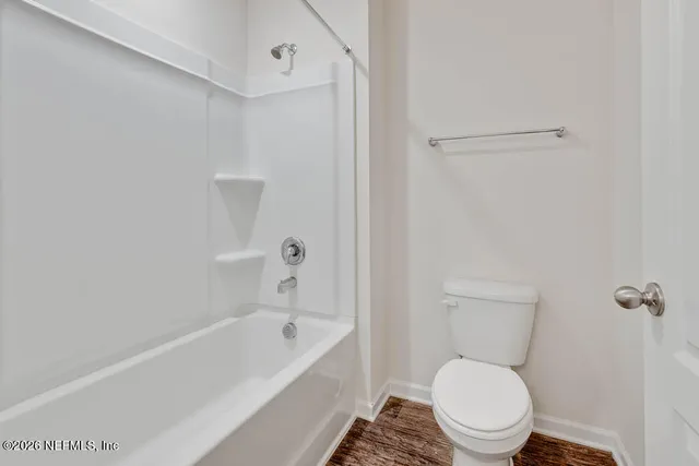 a white toilet sitting next to a bath tub