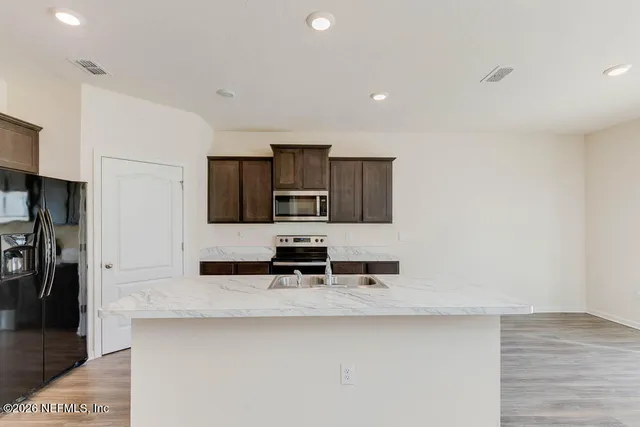 a kitchen with stainless steel appliances a sink stove and refrigerator