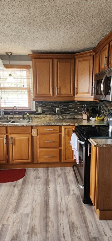 16 Abbott Street Springfield, MA 01118 - Photo 15 of 24 a kitchen with stainless steel appliances granite countertop a stove a sink and a microwave