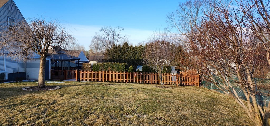 16 Abbott Street Springfield, MA 01118 - Photo 3 of 24 a view of a backyard with wooden fence and large trees
