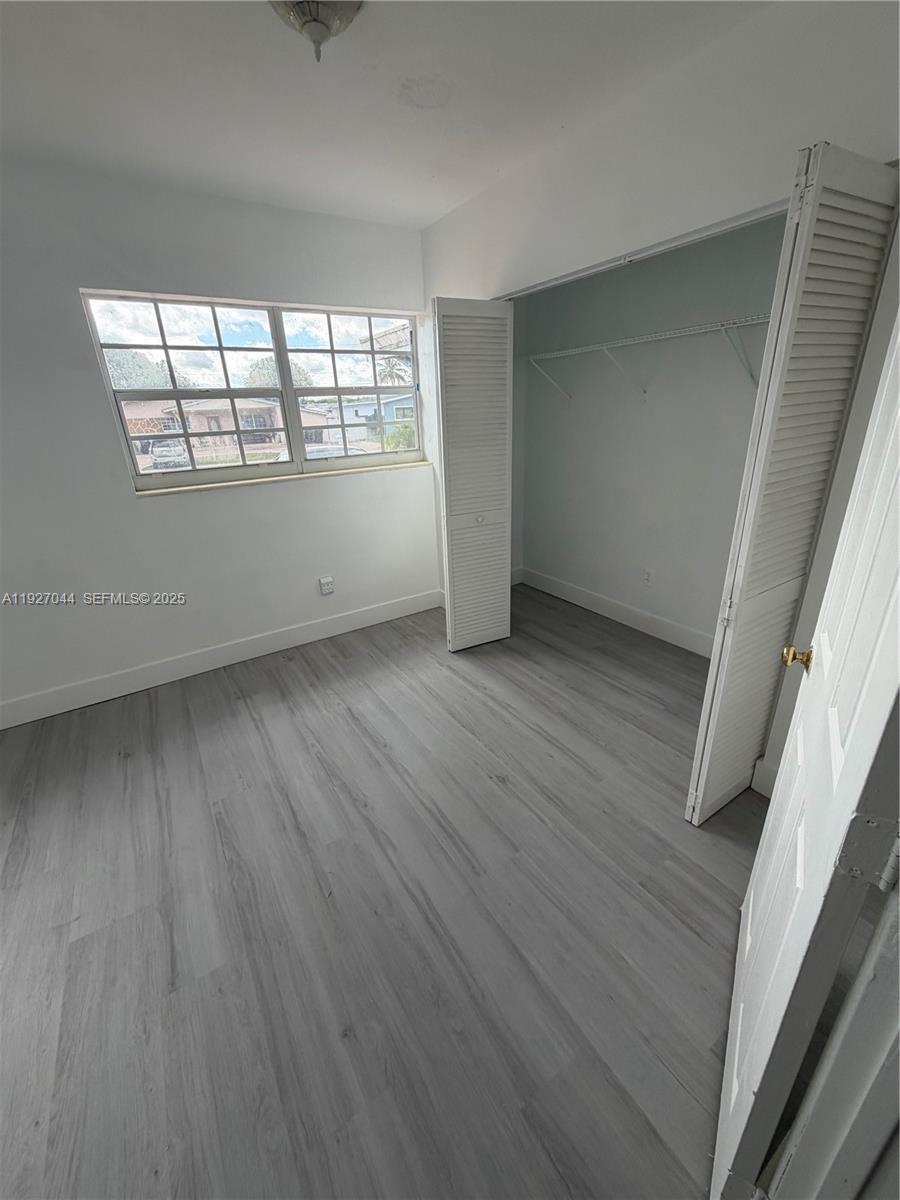 12455 Southwest 185th Terrace Miami, FL 33177 - Photo 11 of 18 an empty room with wooden floor and windows