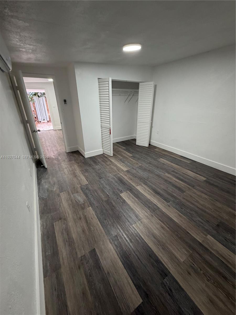 12455 Southwest 185th Terrace Miami, FL 33177 - Photo 14 of 18 an empty room with wooden floor and windows