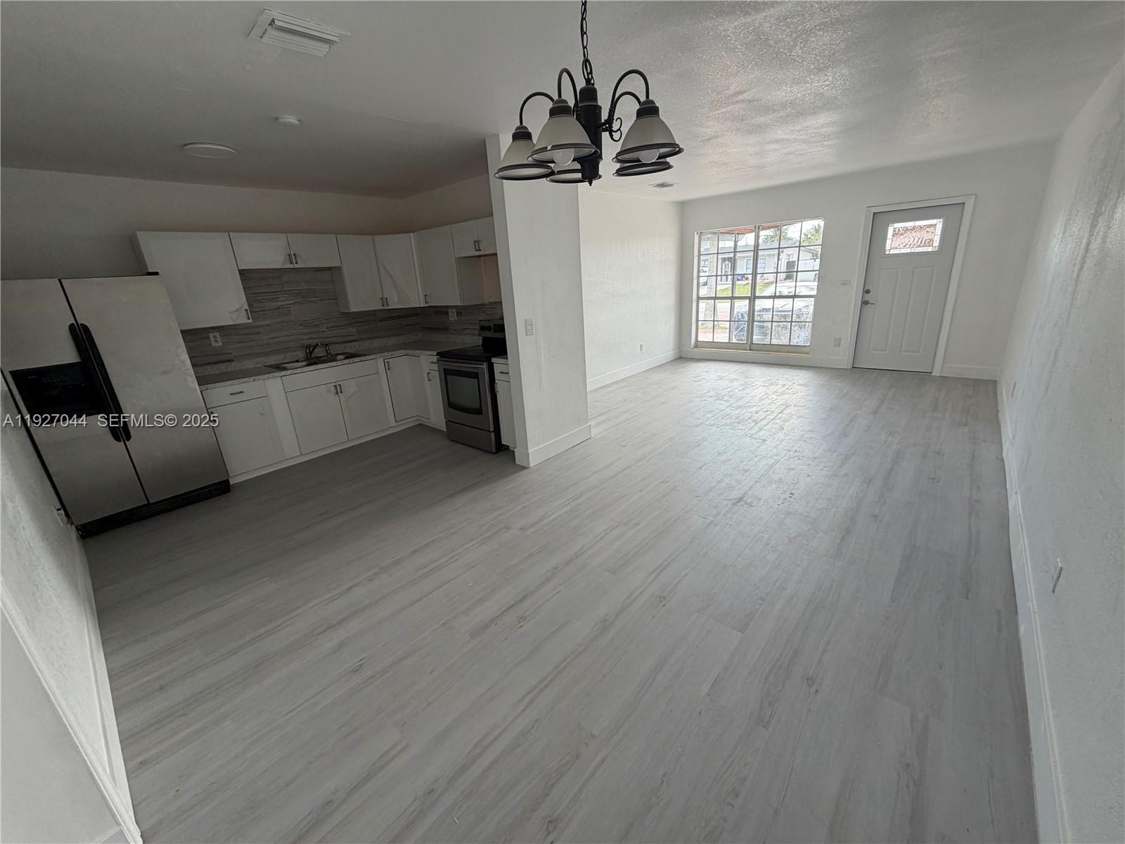 12455 Southwest 185th Terrace Miami, FL 33177 - Photo 3 of 18 a kitchen with stainless steel appliances granite countertop a refrigerator a sink dishwasher a stove and white countertops with wooden floor