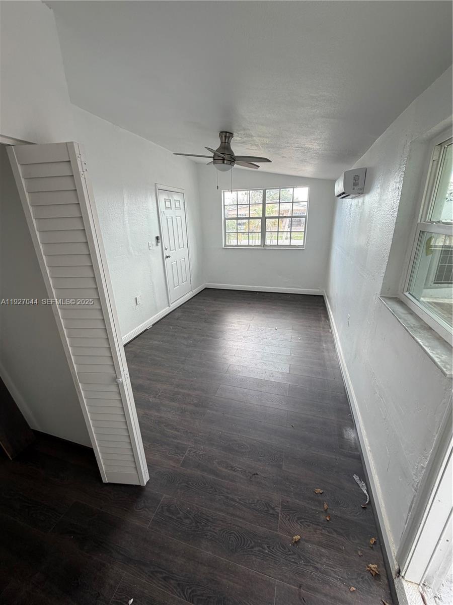 12455 Southwest 185th Terrace Miami, FL 33177 - Photo 5 of 18 an empty room with wooden floor and windows