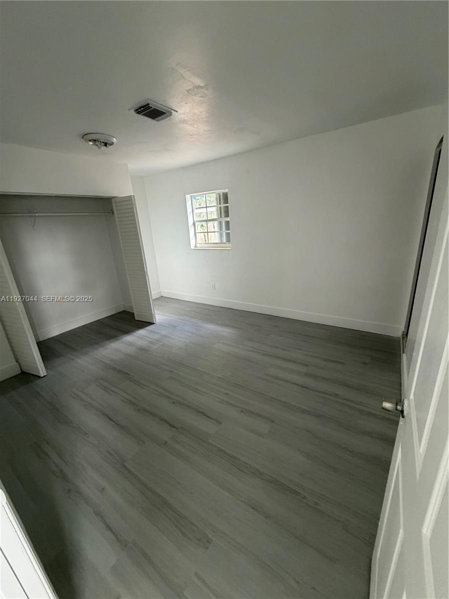 12455 Southwest 185th Terrace Miami, FL 33177 - Photo 9 of 18 an empty room with wooden floor and windows