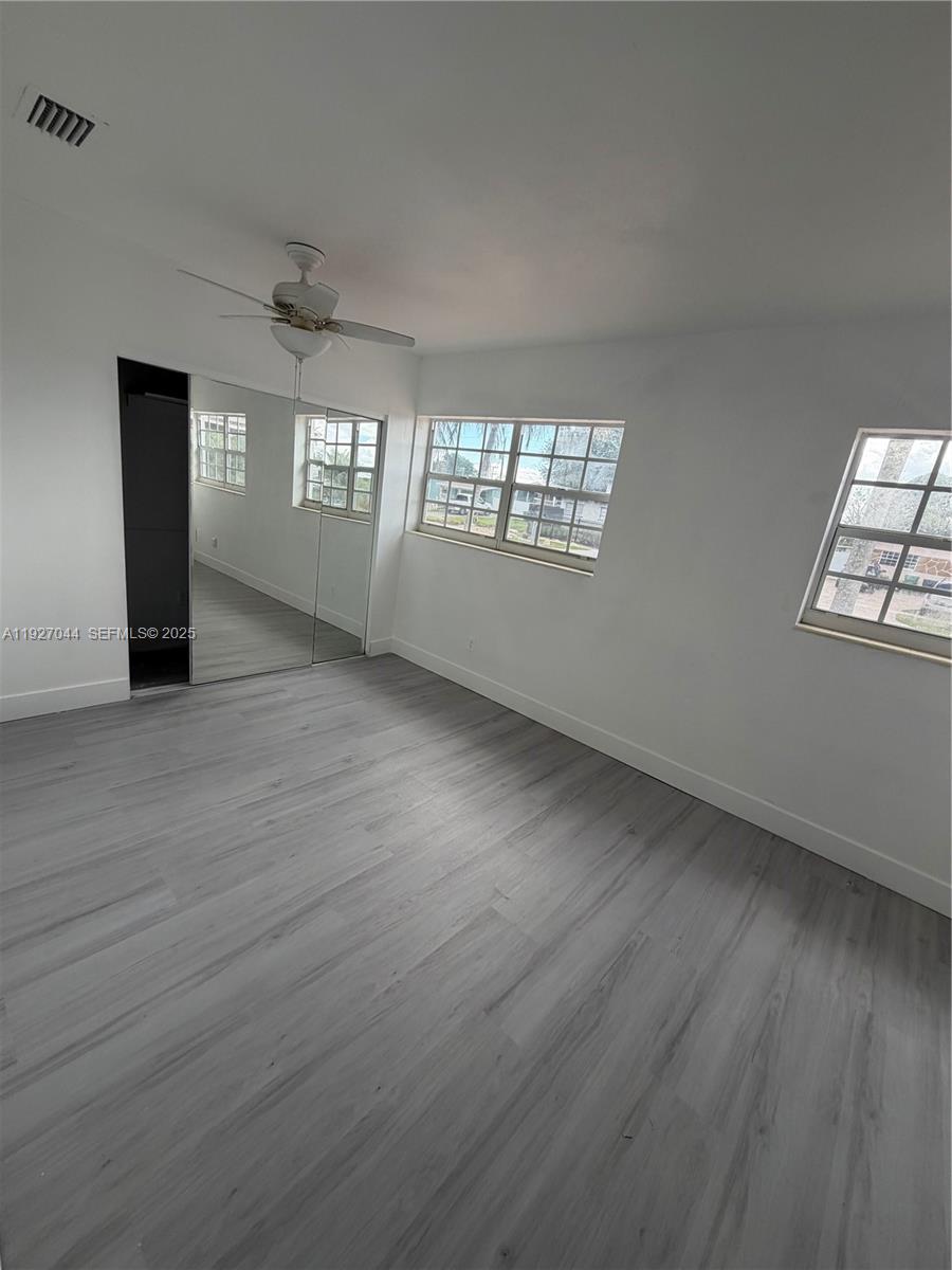 12455 Southwest 185th Terrace Miami, FL 33177 - Photo 10 of 18 an empty room with wooden floor and windows