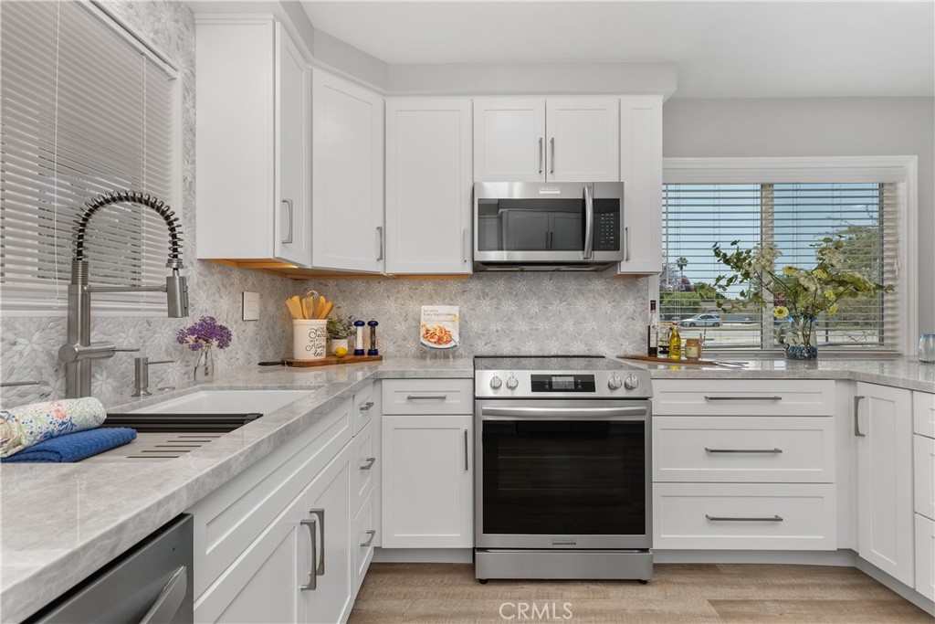 1837 North Studebaker Road Long Beach, CA 90815 - Photo 11 of 38 a kitchen with white cabinets and appliances