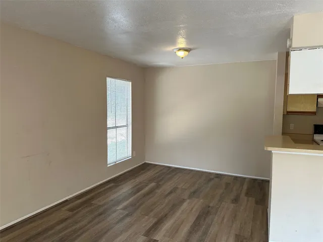 an empty room with wooden floor and window