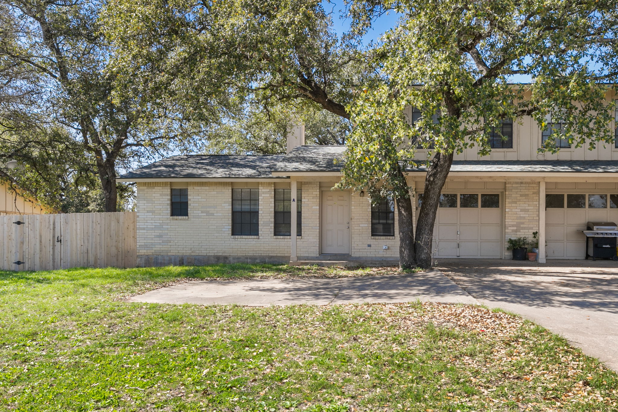 A classic brick exterior, framed by mature trees, welcomes you to this charming residence with convenient garage access.