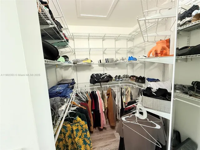 a view of walk in closet with clothes and shoes