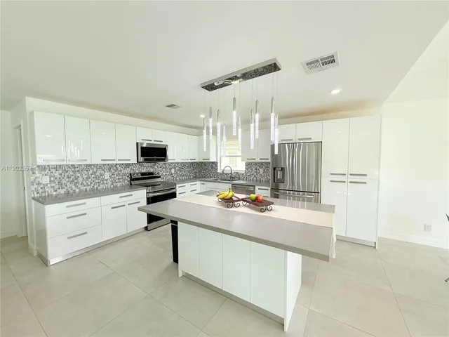 a kitchen with white cabinets and white appliances