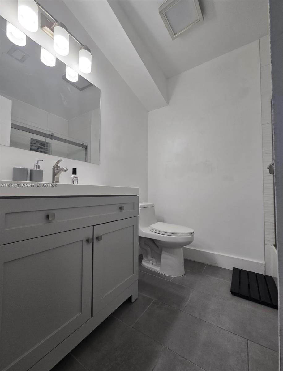10626 Northwest 7th Street, Unit 10626 Pembroke Pines, FL 33026 - Photo 28 of 51 a bathroom with a toilet a sink and mirror