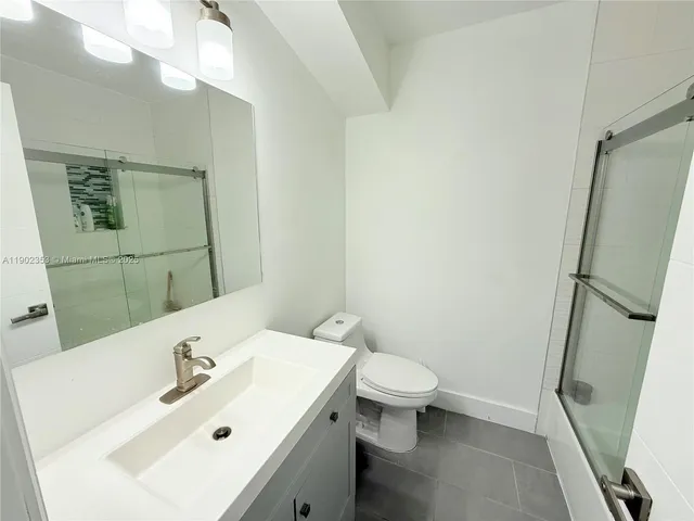 a bathroom with a sink a toilet a mirror and vanity