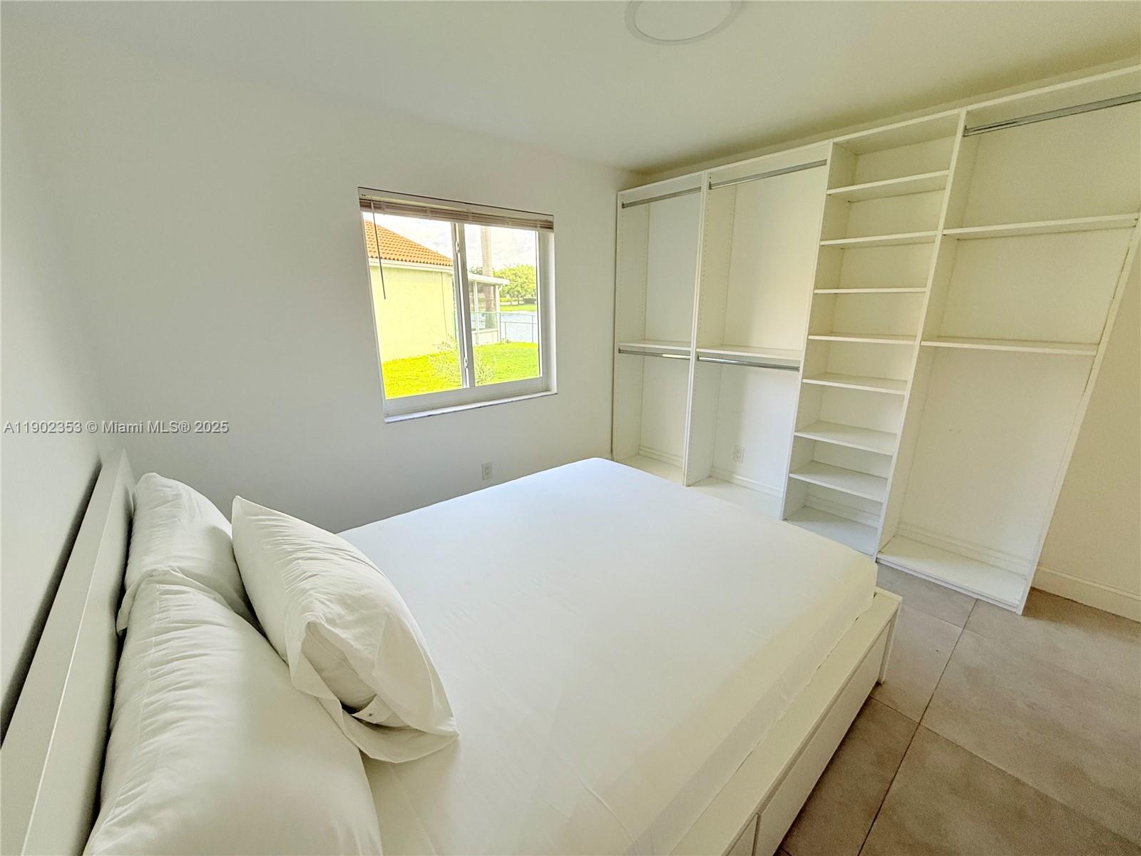 10626 Northwest 7th Street, Unit 10626 Pembroke Pines, FL 33026 - Photo 35 of 51 a bedroom with a bed and a window