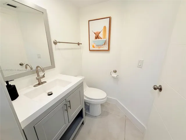 a bathroom with a sink a mirror a vanity and a glass door shower