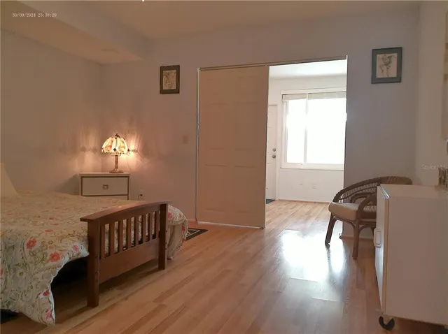 a bedroom with a bed and wooden floor
