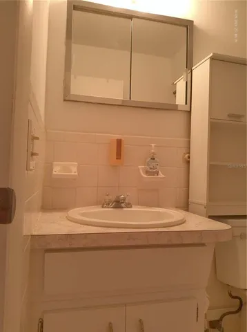 a bathroom with a sink a toilet and mirror