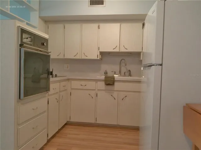 a kitchen with white cabinets and sink