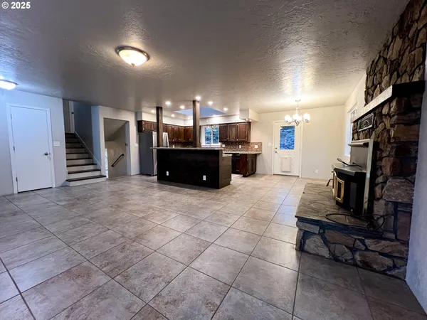 a living room with furniture a dining table and a refrigerator