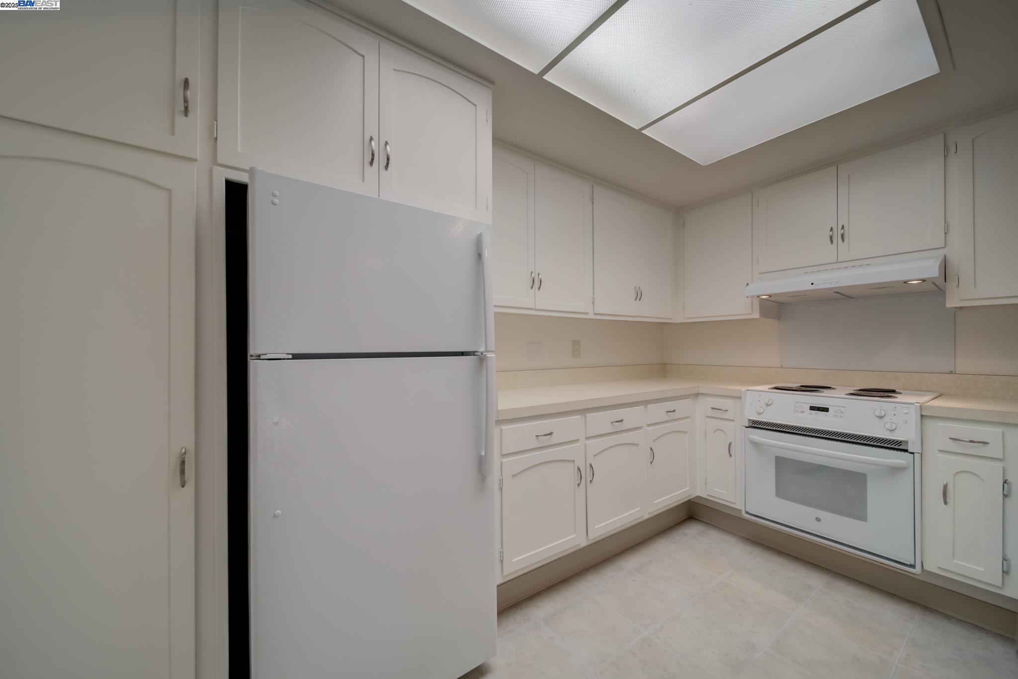 1708 Golden Rain Road, Unit 3 Walnut Creek, CA 94595 - Photo 15 of 23 a kitchen with white cabinets and white appliances