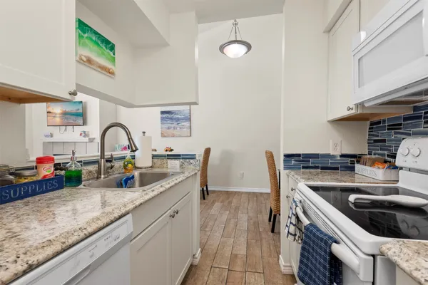 a kitchen with sink a stove and cabinets